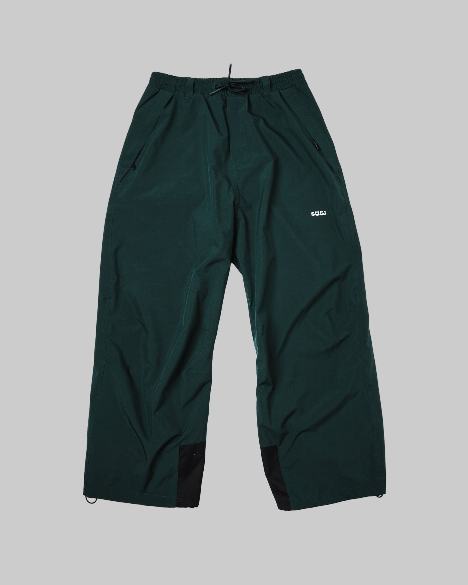 Dark green pants with a brand logo on a light gray background